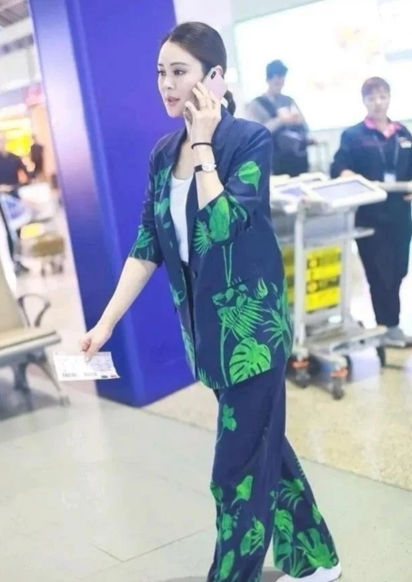 最近关悦现身机场，那身穿搭可太吸睛了！一套西装瞧着花里胡哨的，各种颜色拼接、图案