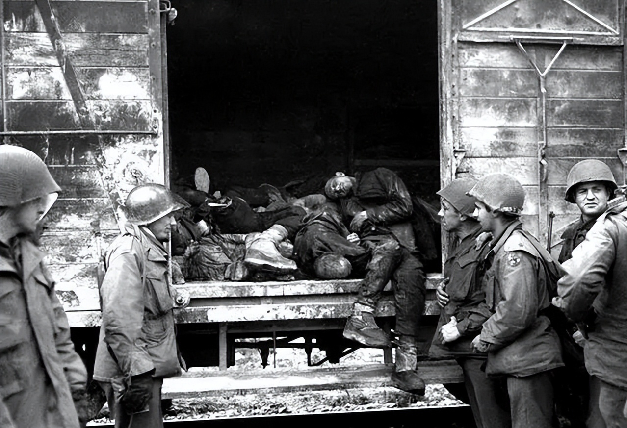 1945年4月29日，在达豪集中营外的列车厢门口，一个党卫军女兵刚刚被美军处死。