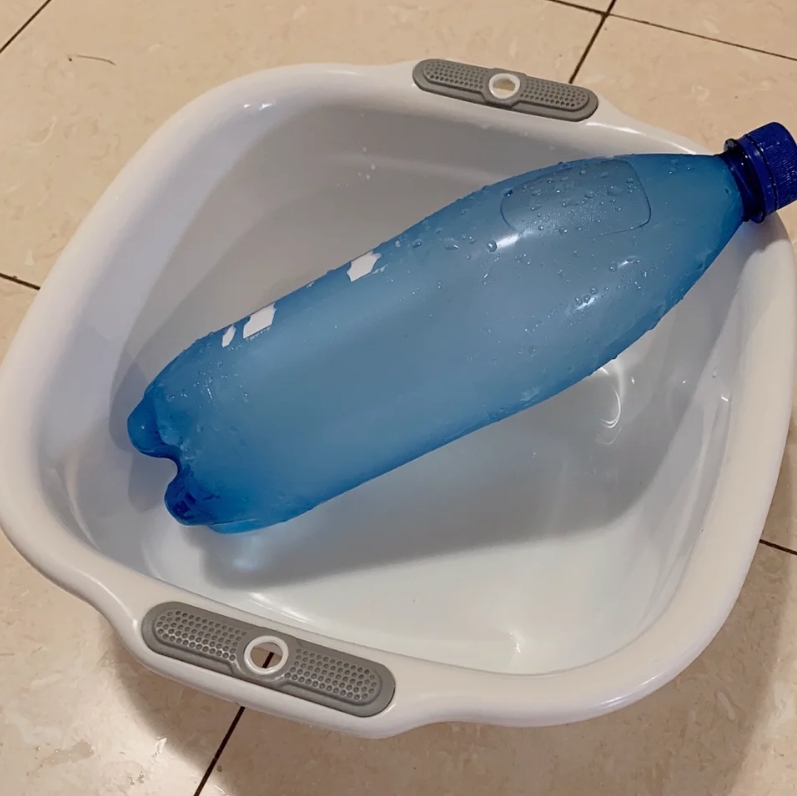 冻成冰的矿泉水瓶放到一个空盆里。

空盆就是为了接住从瓶子上滴下来的水珠的。

