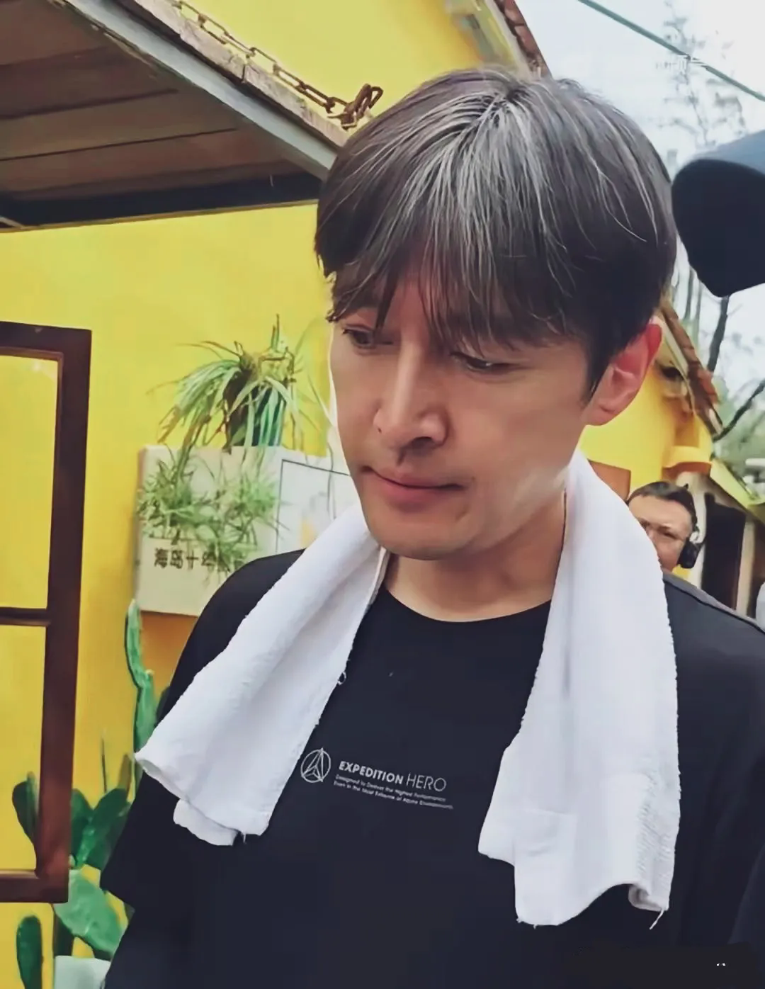 胡歌黑色体恤脖子上搭了白毛巾，头发花白，一脸沉思状，早已步入中年状态。