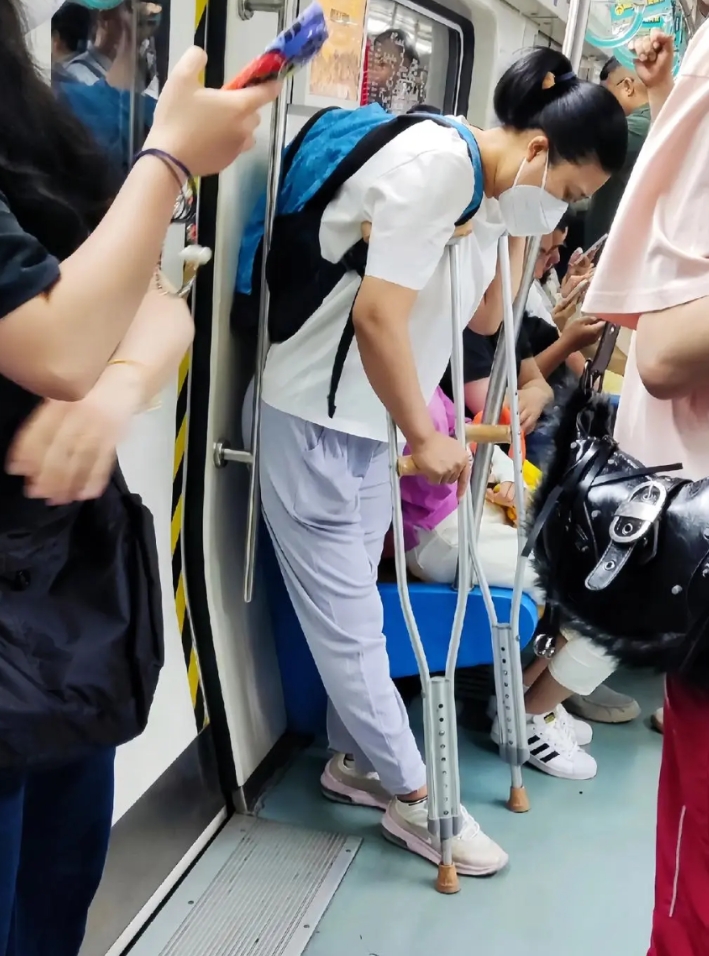 地铁里的人群中这位拄着拐杖的小姐姐，她看起来很难受，旁边坐着的那些人都没看见她吗