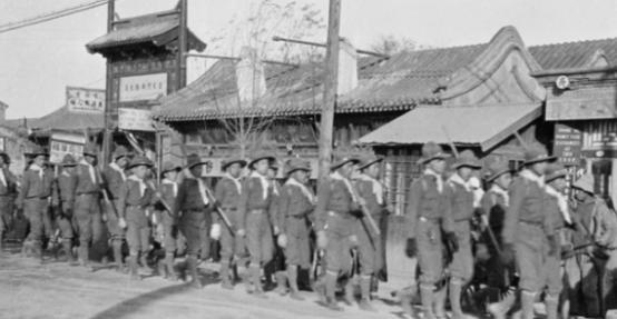 1900年，北京东单牌楼前，清军神机营章京恩海临刑前的照片。镜头下，他戴着脚铐，