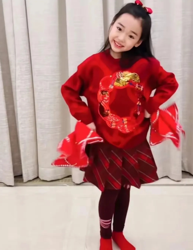 董璇的女儿小酒窝，穿红色卫衣搭配红色小短裙，跳舞蹈可爱极了。

小酒窝手里拿着红