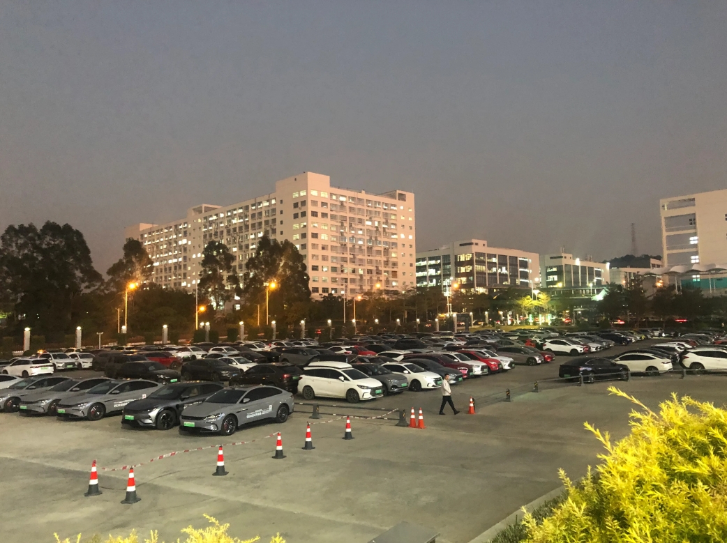 
看一下比亚迪深圳总部的停车场是什么样子？
1.停车场范围很大，远远看去清一色的