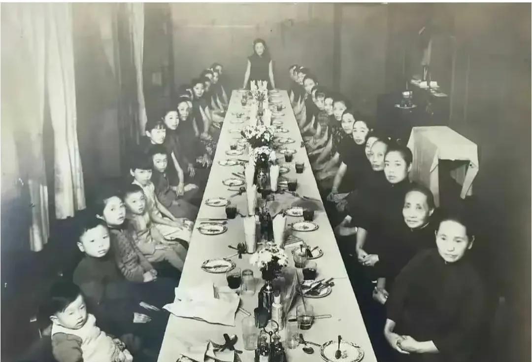 这是1920年，上海荣氏家族聚会所拍的一张照片，十多米长的大餐桌上西餐摆盘，一边