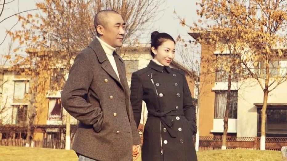 章子怡哥哥携嫂子出游！39岁殷旭大衣丸子头颜值不输小姑子，章子男寸头仔裤似大佬