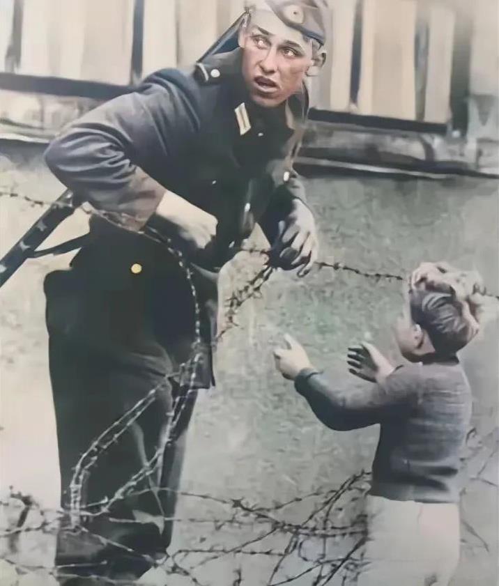 这是1961年柏林墙边的一道铁丝网，铁丝网并不高，但却使很多人骨肉分离。这个小男
