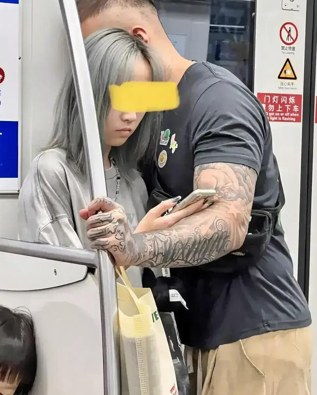 地铁车厢内，有一名身材魁梧的男士紧紧搂着一位大约16岁的少女。少女似乎毫不在乎，