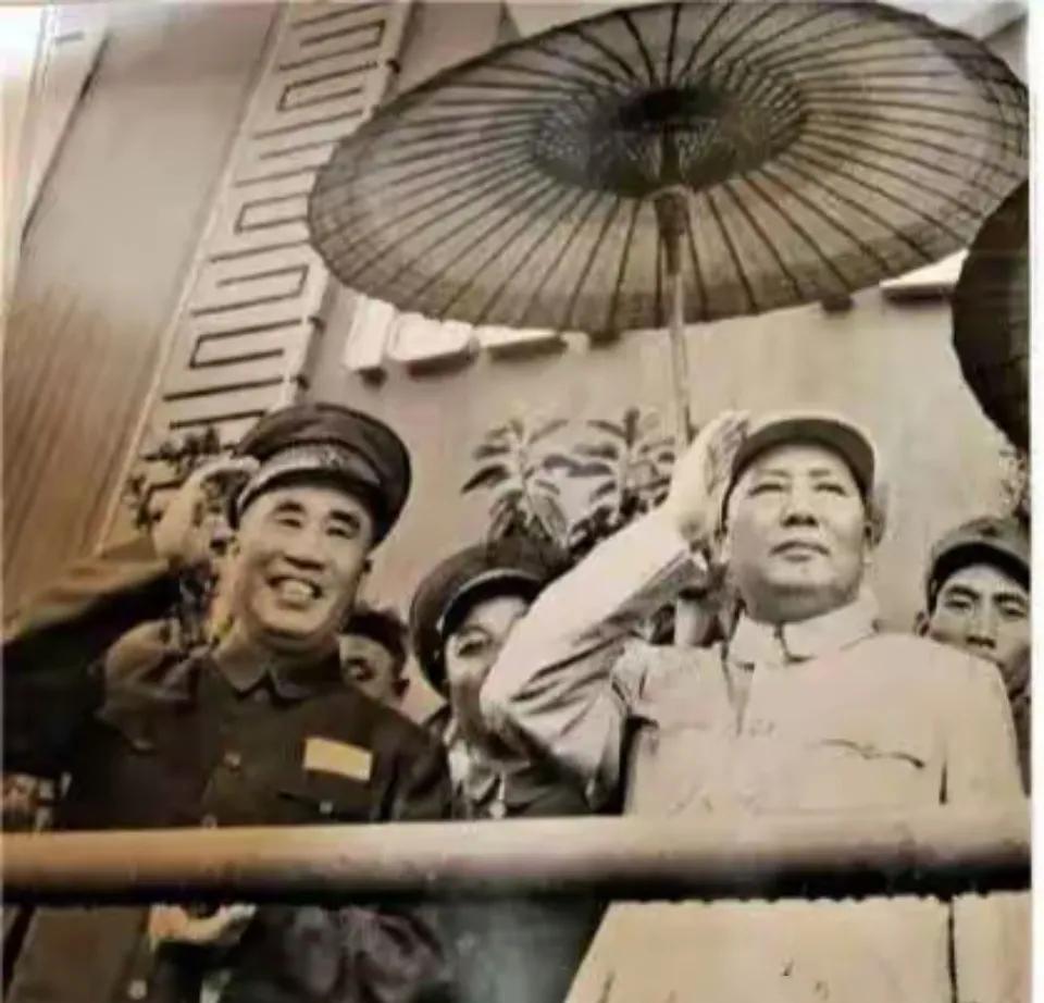 毛主席和朱老总冒雨参加活动，他们同时向台下敬礼，可不多见！
这张照片拍摄于195