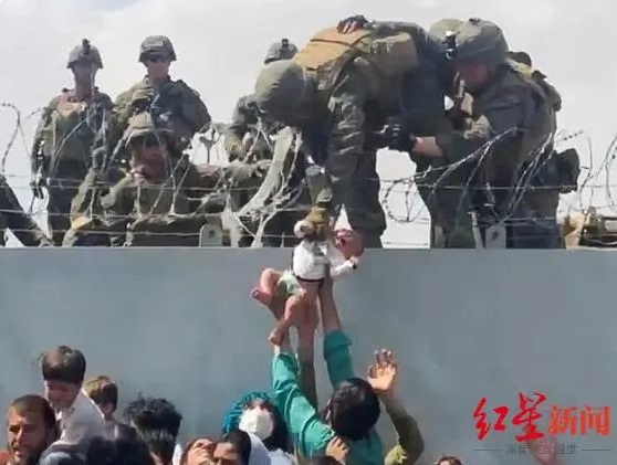美军撤离阿富汗时，一名阿富汗妇女试图将自己孩子送到美军手中，想要让孩子到美国去生