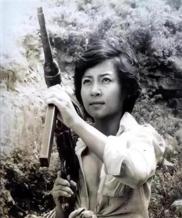 美越战争时期，一名没穿内衣的越南女兵，她目光坚毅，拿枪的样子又酷又性感。照片中依