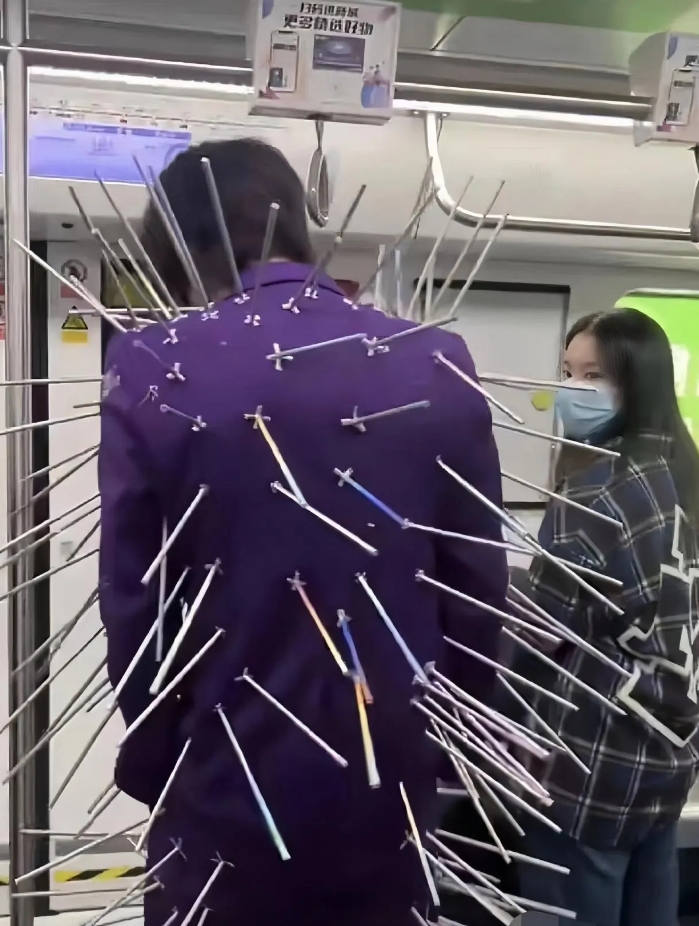 今天做轻轨看到一个人服装怪异！
这是什么衣服？
怎么身上全是箭啊？
看着怪吓人的