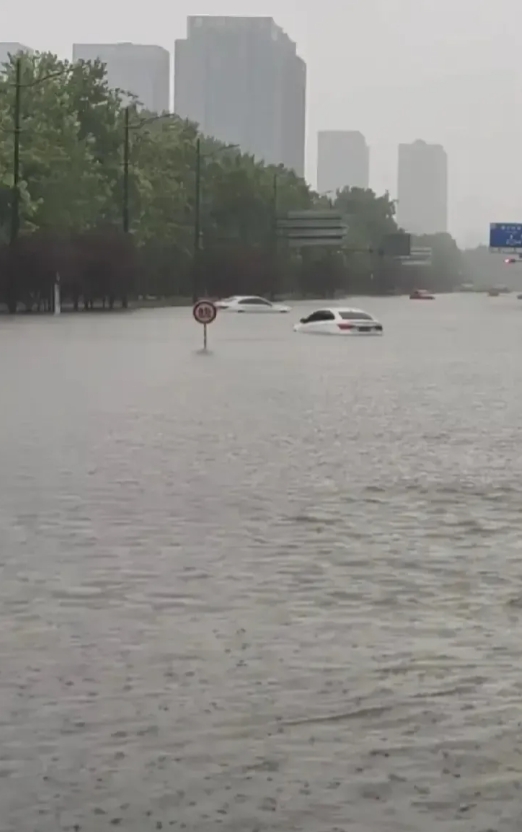 郑州又淹啦！网友晒出视频暴雨已经齐腰深！汽车在水里淌着走，像船一样。还有一位大哥