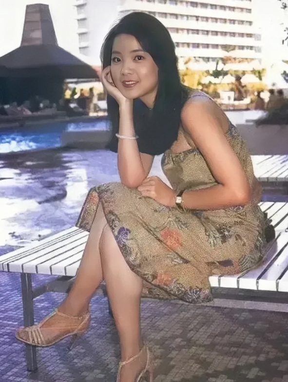 70年代，邓丽君年轻时的珍贵照片。镜头下的她身穿深色花色长裙，脚踩高跟鞋，留着黑