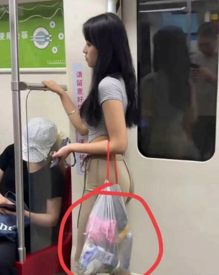 你们看到小姐姐胳膊上的袋子了吗？这小姐姐肯定是起太早了，现在都还没清醒呢，扔垃圾