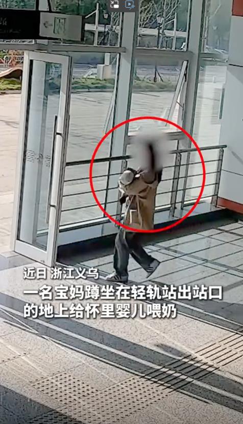 浙江义乌，一名宝妈蹲坐在地上给婴儿喂奶，轻轨站的值班辅警看到后，朝着她走了过来。