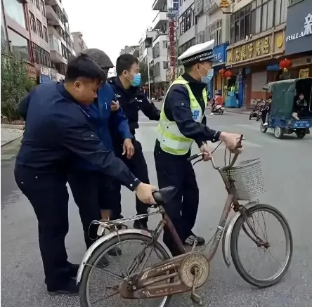 这张照片拍摄于2023年，上海退休法学教授李自忠骑自行车接孙女上放学时，被交警以