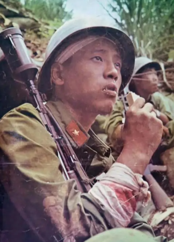 照片上，这个啃着压缩饼干的战士名叫王高银！1987年，老山战场上，越军朝我方弹药
