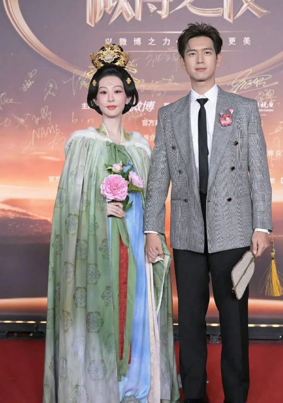 杨紫李现牵手走红毯，杨紫穿着古装雍容华贵，李现一身西装衣领上还别着鲜花意气风发像