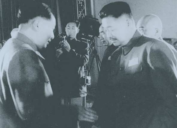 1955年，毛泽东主席正在给贺龙元帅授衔。他前面是两位老总，朱德元帅和彭德怀元帅