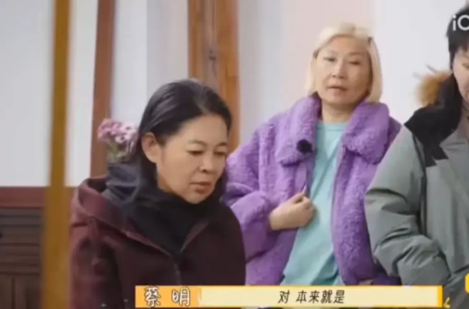 李小冉坐在地上，几个老太太站着，李小冉拉着脸像训孙子一样训几个老太太：“都是我和