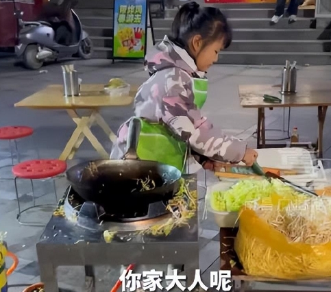 9岁小女孩写完作业后，帮爸爸摆摊卖炒饼。小女孩称，爸爸白天要打一份工，晚上还要干