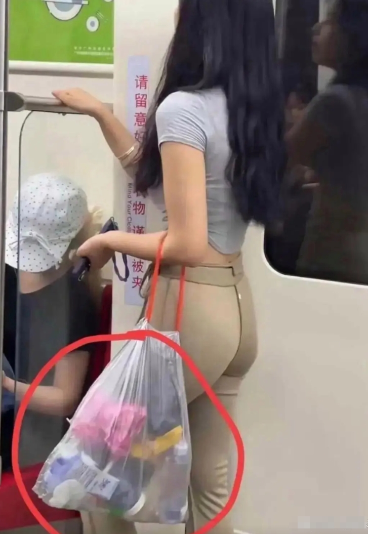 哇塞！这妹子咋回事呀？难道是睡迷糊啦！居然拎着个垃圾袋就钻进了地铁。瞧她那懵懵懂