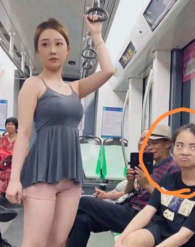社会现象点评：在地铁上见到了一幕，大姐的表情也是亮点，估计心里在吐槽这啥衣服啊！
