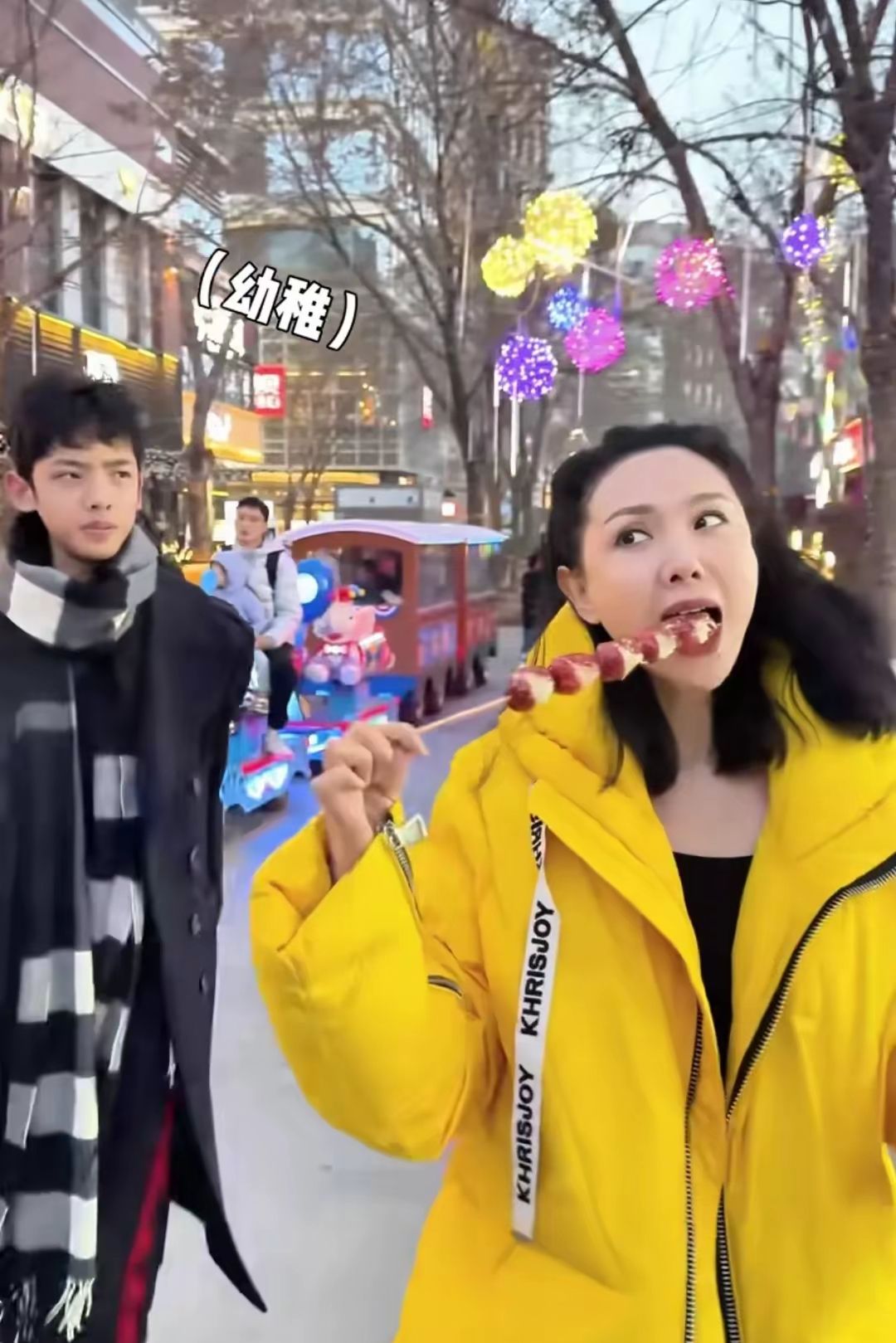 47岁程莉莎和儿子逛街，吃冰糖葫芦撒娇拍照，少女感十足让人羡慕，儿子颜值也很高