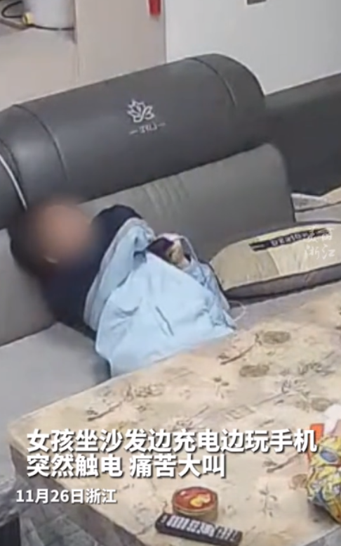 太危险了！11月26日，一女孩正坐在沙发边上一边充电一边玩手机，突然，女孩触电导