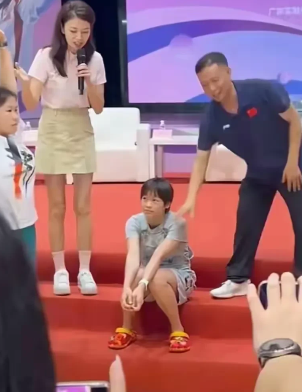 全红婵，悄然间，轻坐于台阶之上，此举非但无失礼之处，实则蕴含三重深意：

1. 