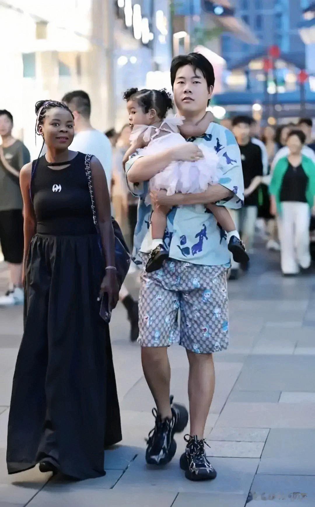 帅气的中国小伙子娶了个漂亮的黑人媳妇。一家三口走在熙熙攘攘的大街上，看上去温馨无