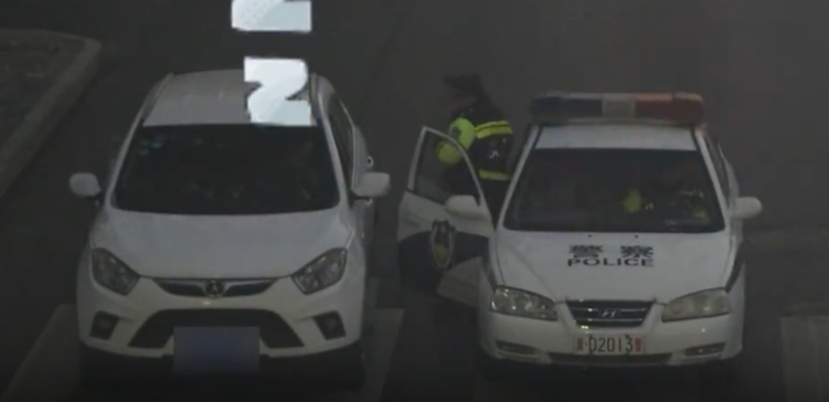 一辆小轿车停在路中间，过路车辆纷纷绕行，可司机却对此毫不知情，躺在车上呼呼大睡，