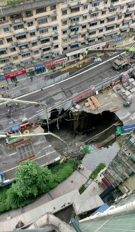 都市地铁13号线一在建站点发生坍塌，露出地面下的巨大空洞。
在图片中看到一条马路