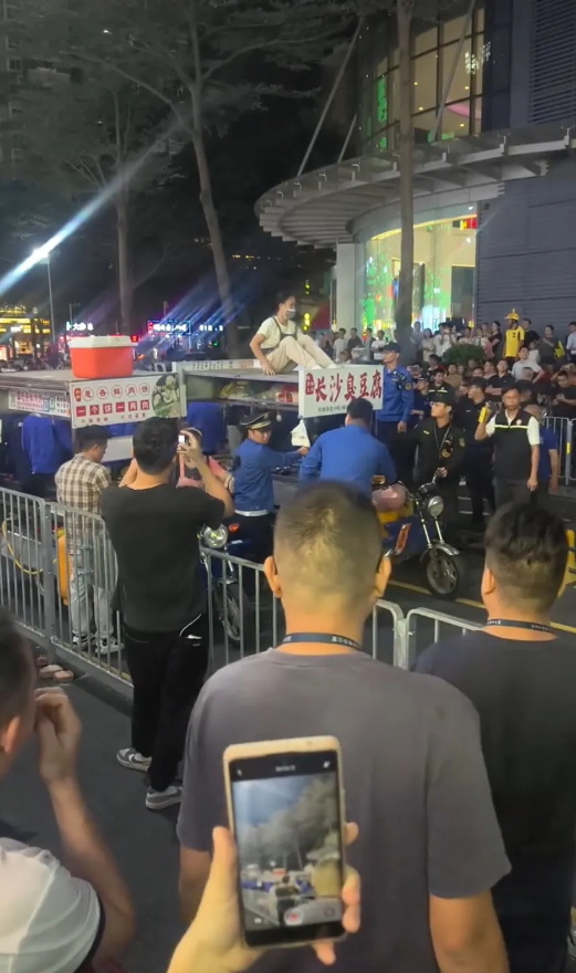 深圳一街头城管在整治三轮车摊贩乱停占用车道。现场一名被没收三轮车的老板娘坐在三轮