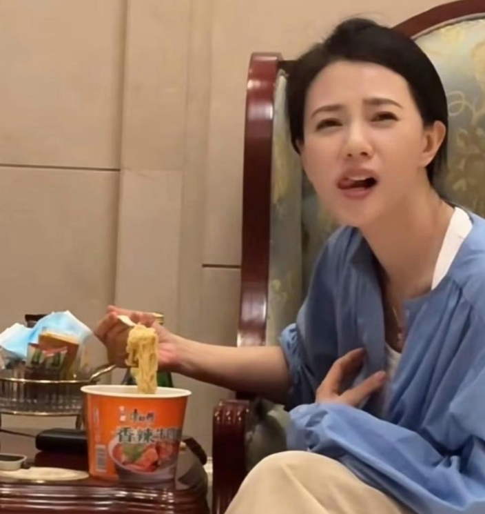 高圆圆机场候机吃泡面充饥，吃泡面的样子特别随意，双腿轻叠，发丝随性一夹，尽显生活