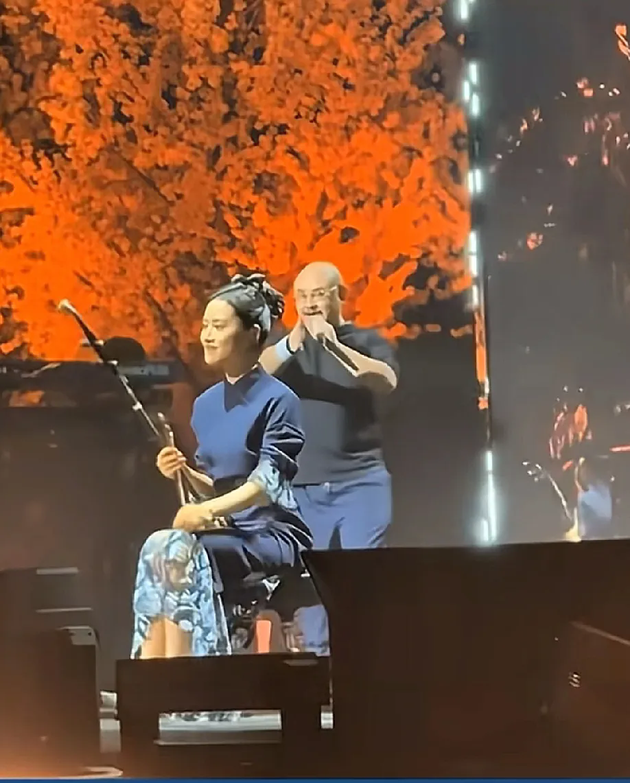 王乐身着旗袍，手持二胡，仪态优雅地坐在台上。紧接着，二胡声起，那乐音刚劲有力，看