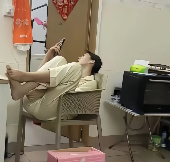 老铁们，瞧瞧这张图片，一个女人坐在办公室里，一点也不守规矩，你看她翘起二郎腿的脚