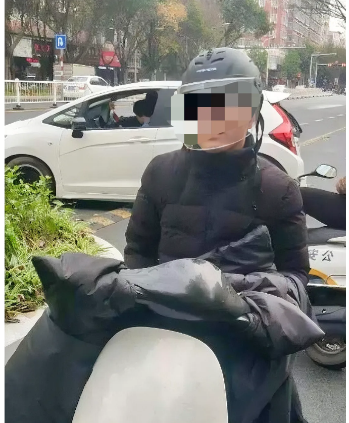 上海闵行，一男子戴着头盔、骑着电动车去上班时被交警以未系安全带卡扣为由，处以行政
