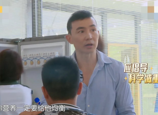 刘畊宏艰难地抱起一个比较胖的小男孩，小男孩妈妈心疼地说他在减肥，刘畊宏并不赞成: