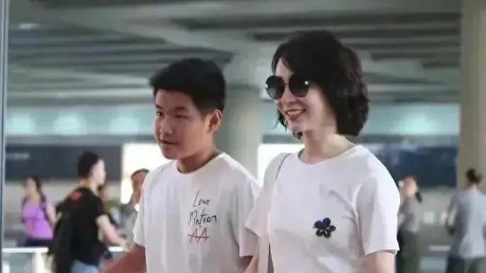 陈数和18岁儿子手牵手走机场，她打扮年轻靓丽，不像母子像姐弟