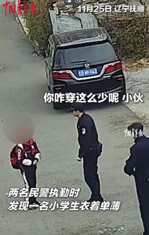 这两个交警火了！辽宁抚顺，一名小男孩衣着单薄背着书包走在路上，碰巧被两名民警看到