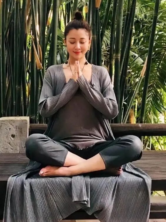 殷桃坐在一片竹子前打坐冥想，美人静坐是不错的休息方式，陶冶性情一动一静，这个休闲