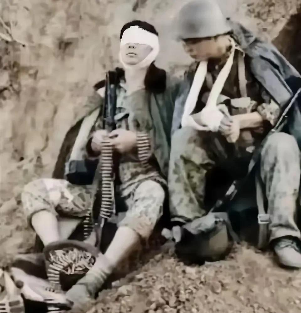 这是一张感人至深的照片，战地记者拍摄于当年的老山前线。
两名战士都负伤了，一个伤