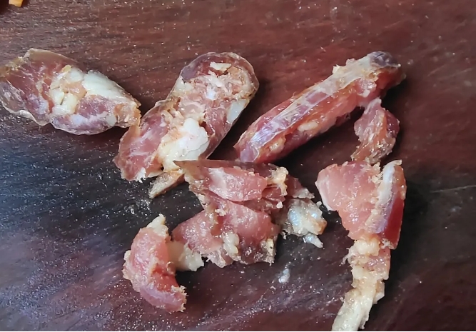 这是晒了一周的腊肠，外面摸着已经硬了，但是切开，里面的肉还没成型，还是吃不成，这