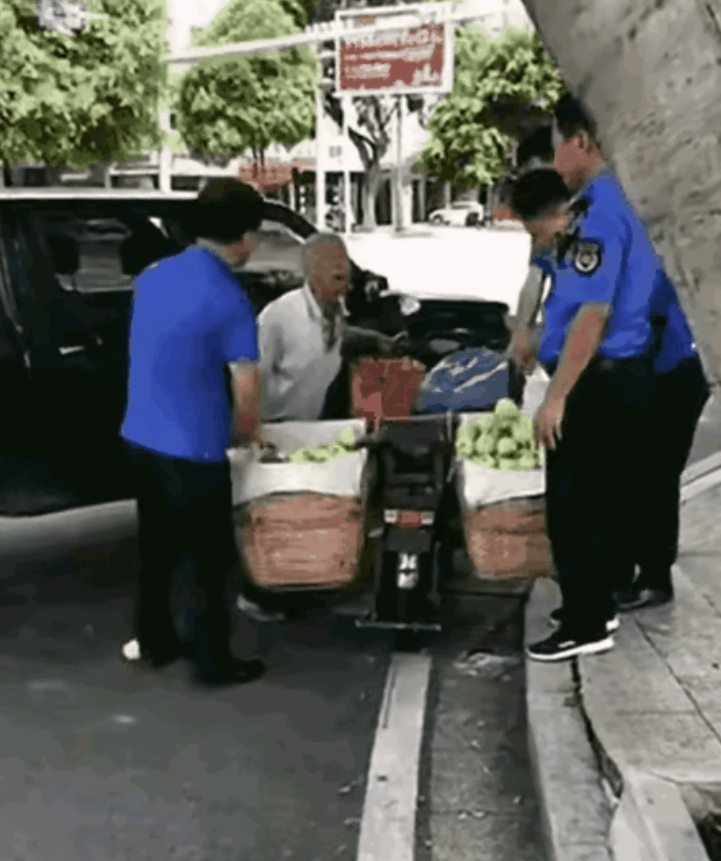 几个城管人员驾驶着皮卡车，拦下了一位沿街售卖水果的大爷。他们开始将大爷的水果一箱