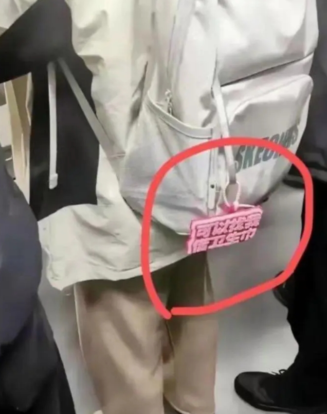 在地铁上看到一个小姑娘，看样子好像是个学生，她背的包包上有一个红色的牌子吸引了我