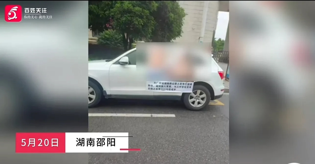 湖南邵东，一辆白色的SUV车左侧贴着一副海报，海报的内容让人不忍直视。一对男女全