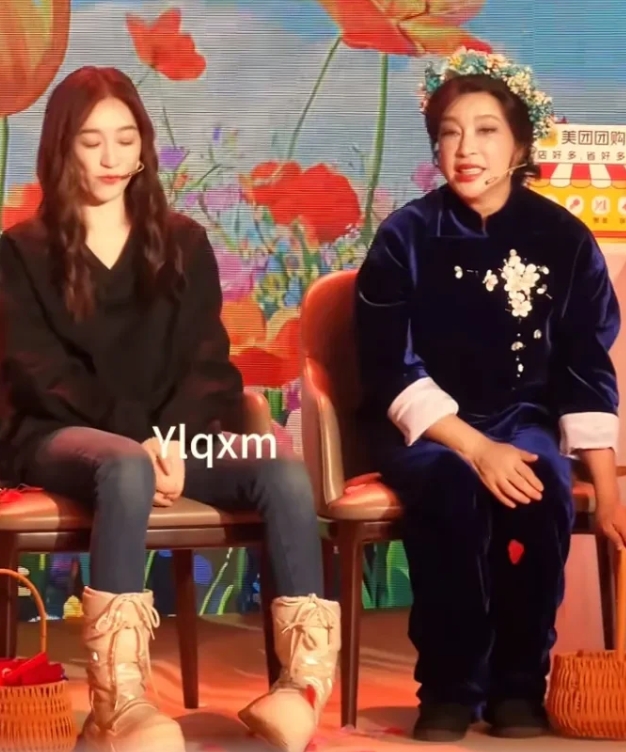 70多岁的刘晓庆将篮子里的花瓣撒在她人头上，
又蹲下捡起的地上的花瓣置于自己头上