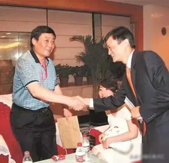 当宗庆后与马云握手时，桌子前摆放着一盒敞开的烟，而旁边则坐着宗馥莉，三人的体态对
